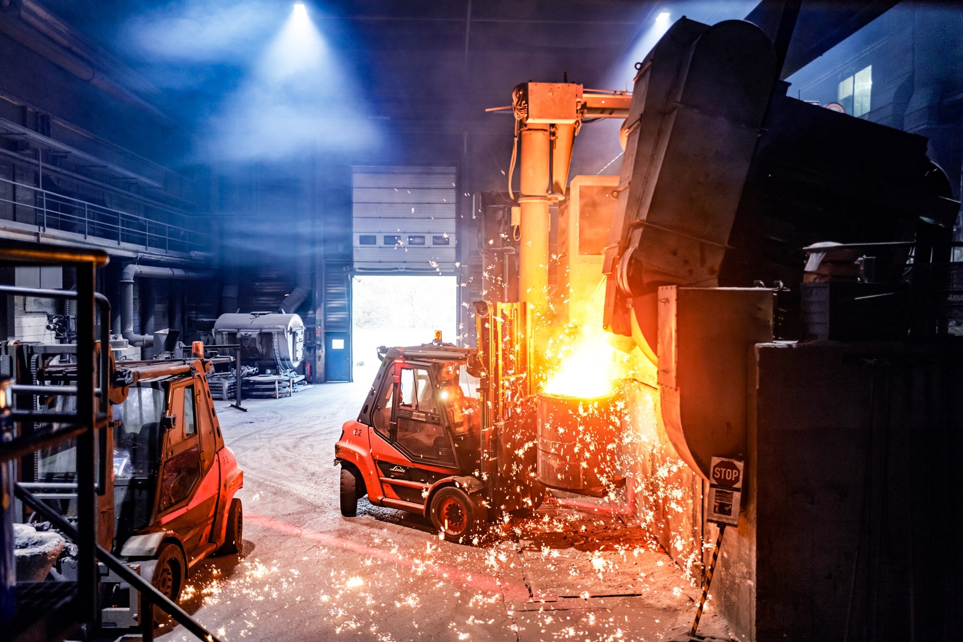 A forklift transports a barrel of molten iron through a foundry